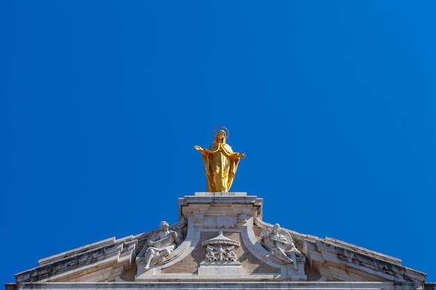 Foto scultura dorata della madonna in cima alla basilica di santa maria degli angeli, assisi, italia