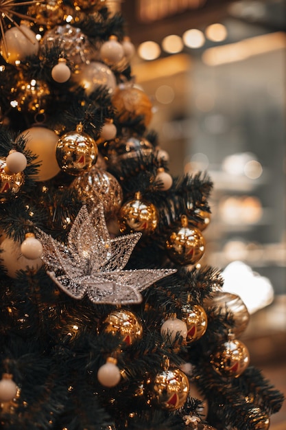 Golden magic Christmas balls with glittering ornament and crystal star hanging on the Christmas tree branches Winter holiday fairy decorations and festive details in the interior