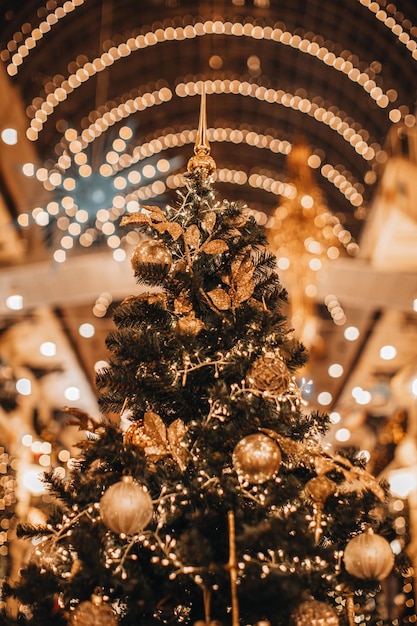 Golden magic Christmas tree decorated with glittering garland and shiny Christmas balls New Year