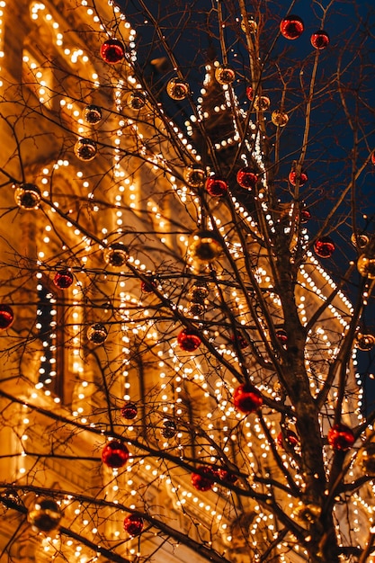 Golden magic sparkling vintage building and tree branches decorated with Christmas balls