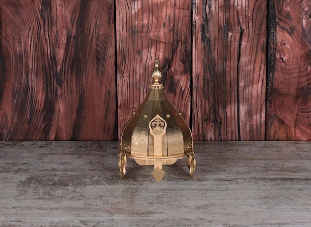 golden medieval helmet on wooden table