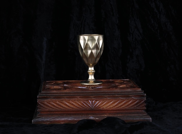 golden medieval wine glass on black velvet
