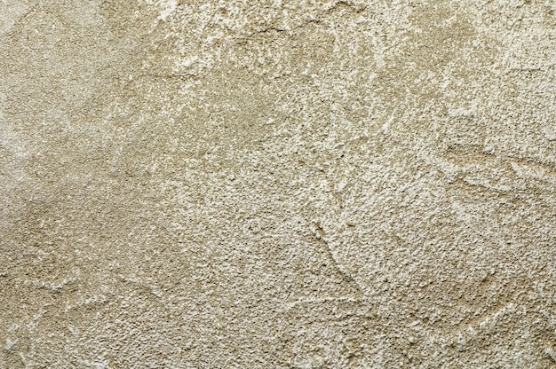 Golden messy wall stucco texture. Closeup decorative plaster paint for background.