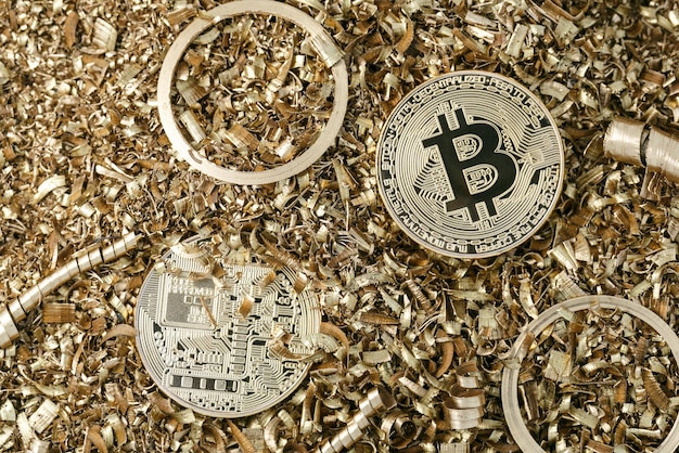 金属の削りくずを背景にビットコインの象徴的なバージョンとしての黄金の金属コイン。暗号通貨と新しいデジタル決済システムの概念。