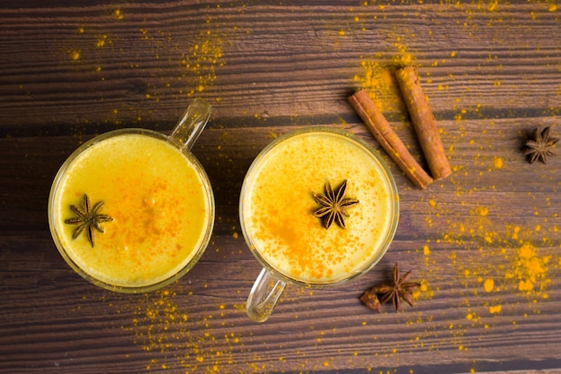 Golden milk drink with turmeric and honey on a dark wood