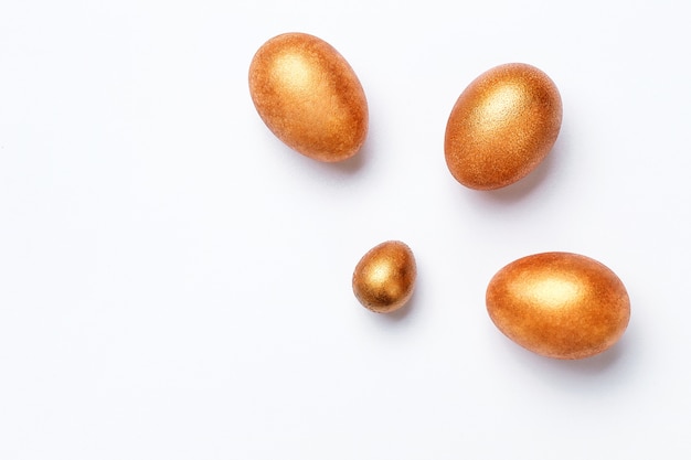 Golden modern easter eggs on a white background. Top view. Isolated.