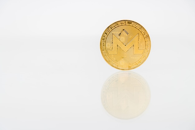 Golden Monerd coin with reflection on the table, online digital currency.