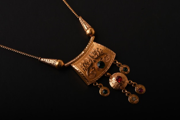 Golden necklace with isolated on black surface