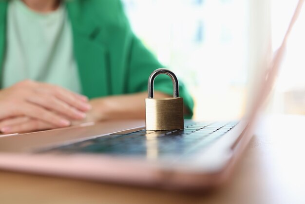 Foto lucchetto dorato sulla tastiera del computer portatile e manager femminile in background