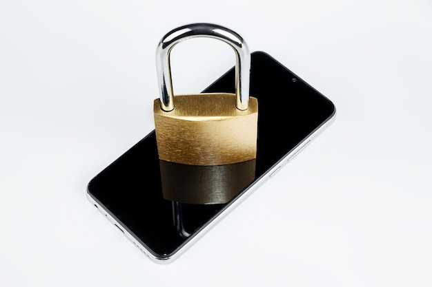 Golden padlock lies on a smartphone isolated on a white