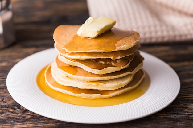 Golden pancakes with butter and warm maple syrup.