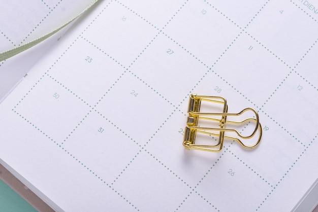 Golden paper clip on calendar organizer notebook