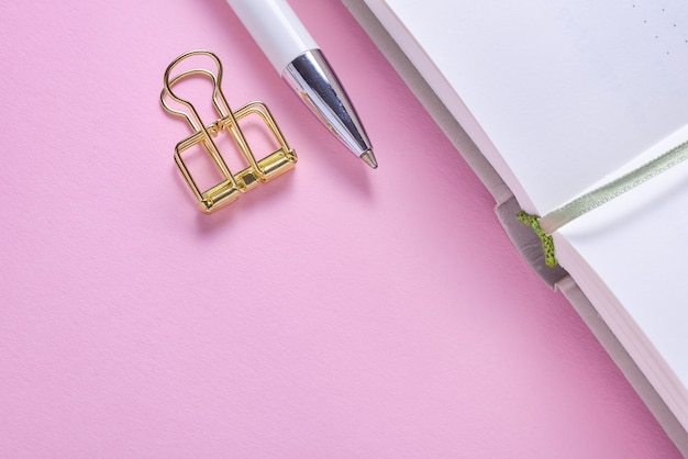 Golden paper clip and pencil on calendar organizer notebook