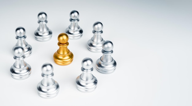 コピースペースと白い背景の上の銀のポーンのチェスの駒のグループの真ん中に立っている金のポーンのチェスの駒は、群衆から際立っていますリーダーシップユニークなインフルエンサーの違いの概念