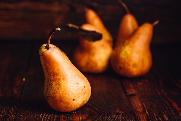 Golden Pear on Wooden Table and Few Pears