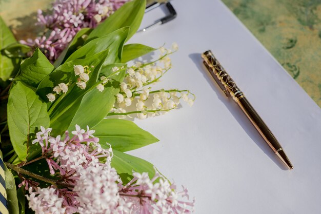 Photo golden pen and blank paper on a wooden table