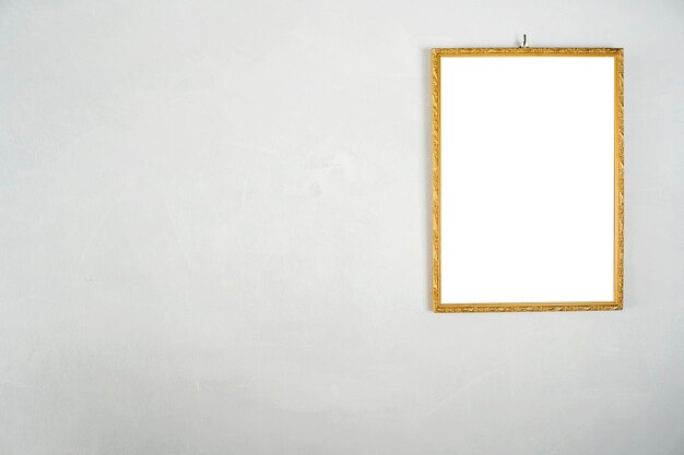 Golden picture frame hanging on a white cement wall White label floor for text images advertising media