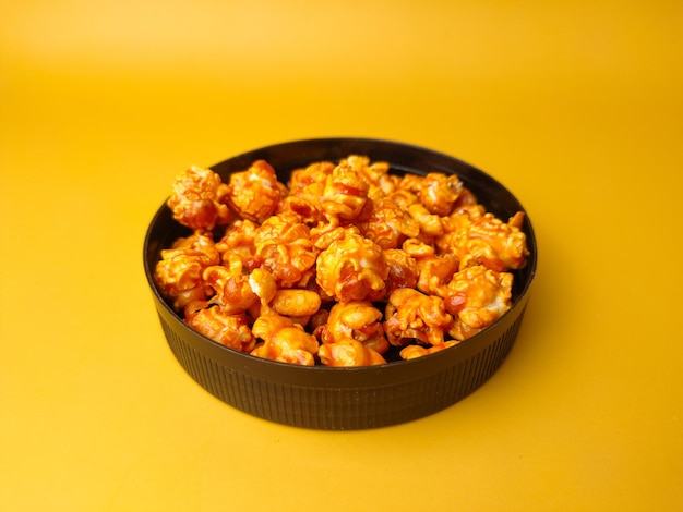 Golden popcorn on a yellow background with copy space