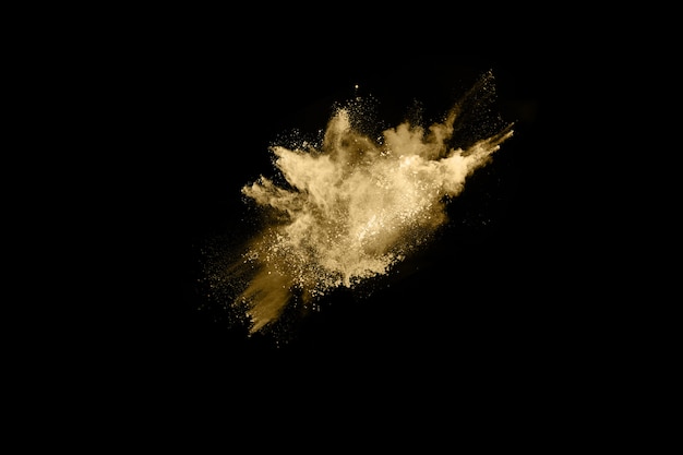 Golden powder explosion on black background. Freeze motion. 