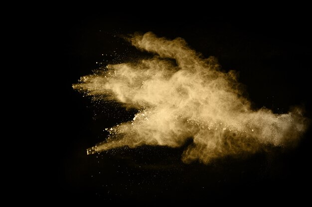 Golden powder explosion on black background