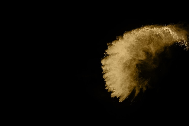 Golden powder explosion on black background.  