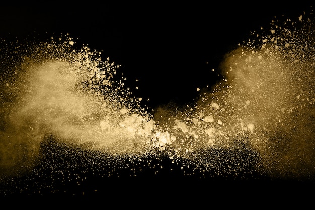 Golden powder explosion on black background.  