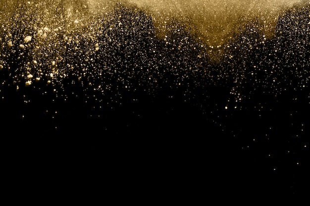 Golden powder explosion on black background.