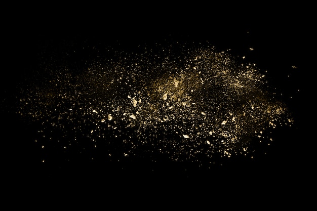 Photo golden powder explosion on black background.