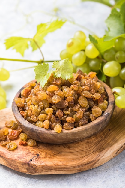 Golden raisins in bowl on stone background