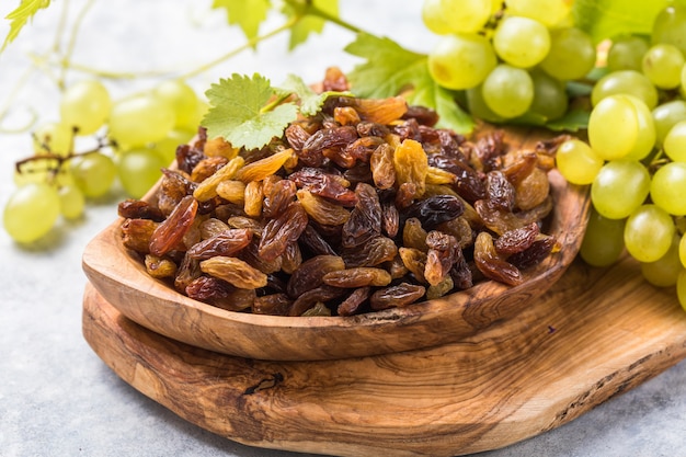 Golden raisins in bowl on stone background