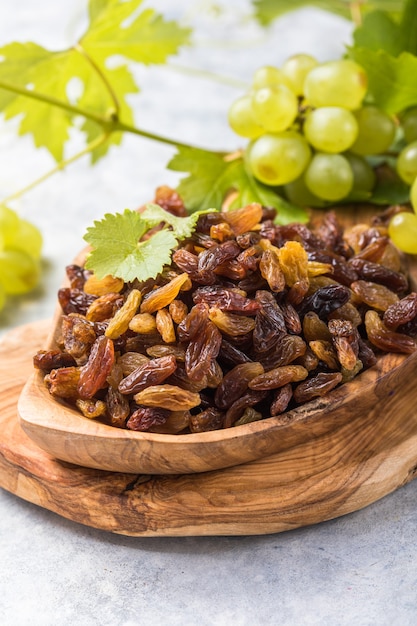 Golden raisins in bowl on stone background