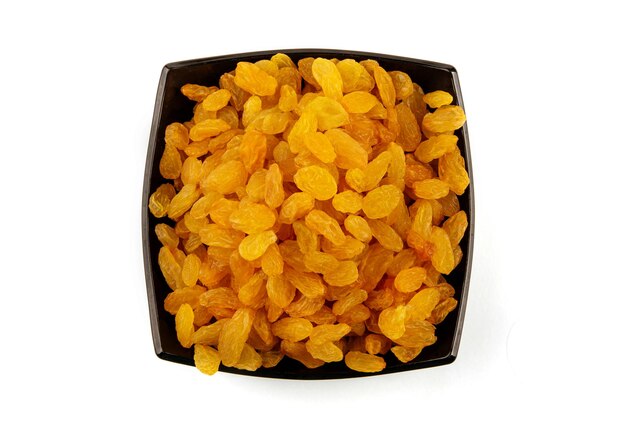 Golden raisins in a dark plate isolated on a white background