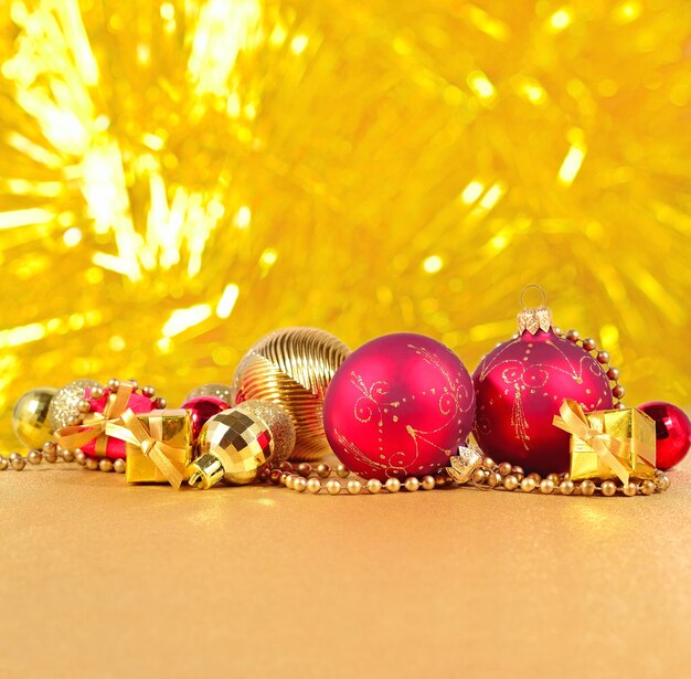 Золотые и красные рождественские украшения на золотом фоне