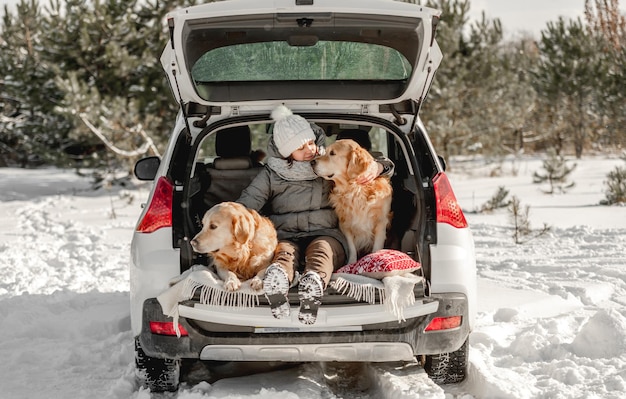 Golden retriever-honden met meisje in de winter