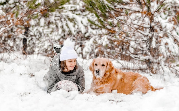 Golden retrieverhond met meisje in de winter