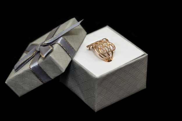 Golden ring in gift box isolated on black