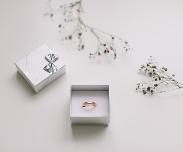 Golden ring and jewelry box and flowers, proposal of marriage concept