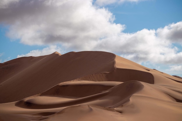 나미브 사막의 화창한 날 황금빛 모래 언덕 7과 흰 구름. 여행자와 사진 작가를 위한 환상적인 장소