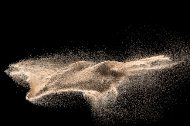 Golden sand explosion isolated on black background