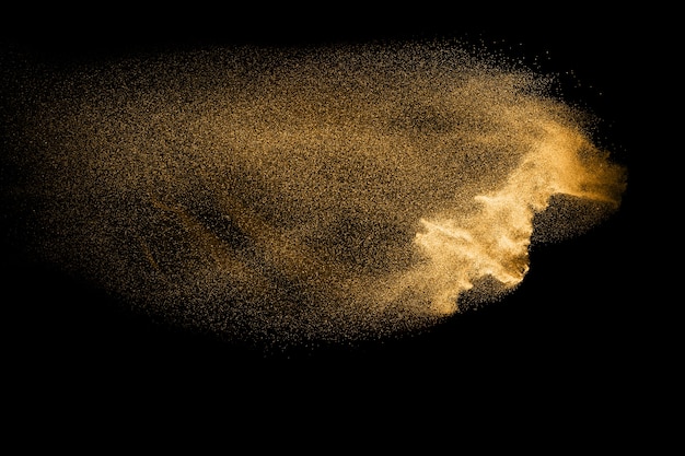 Фото Золотой песок взрыв, изолированных на черном фоне.