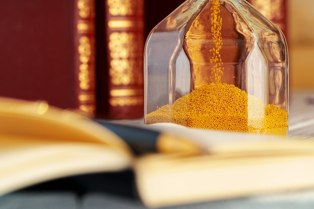 Golden sand hourglass close up on working table