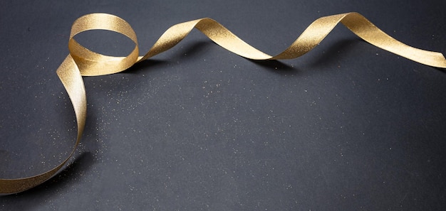 Photo golden satin ribbon on black background copy space