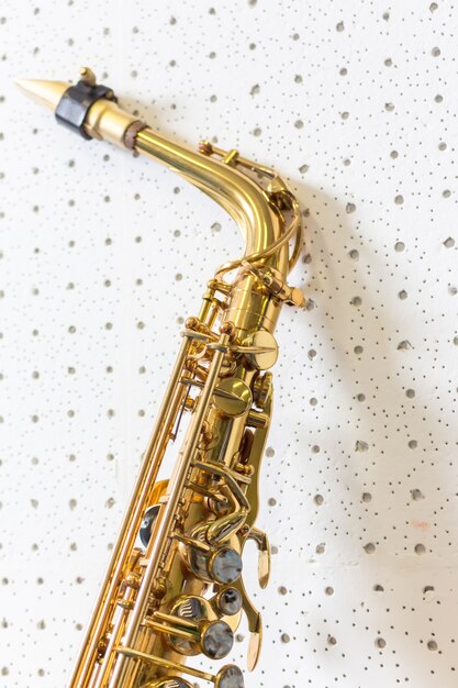 Golden saxophone on white wall background