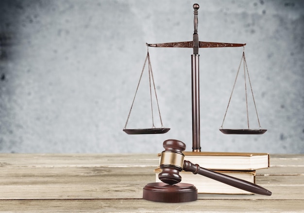 Golden scales of justice, gavel and books isolated on white