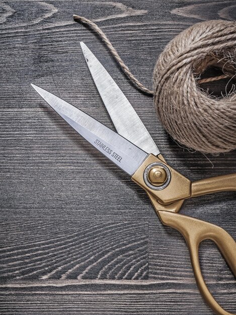 Golden scissors hank of string on vintage wooden board