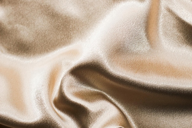 Golden shiny texture of silk satin satin with folds