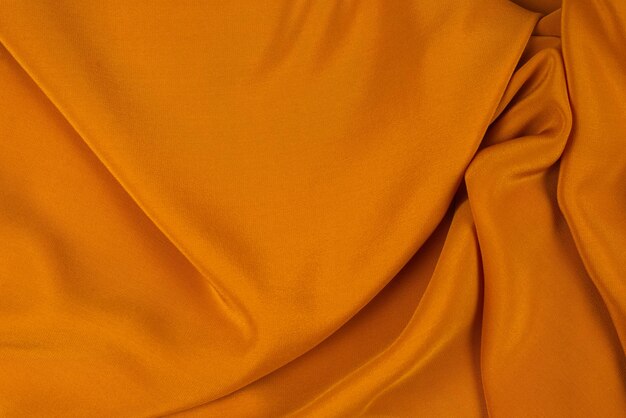 Golden silk or satin luxury fabric texture can use as abstract background top view