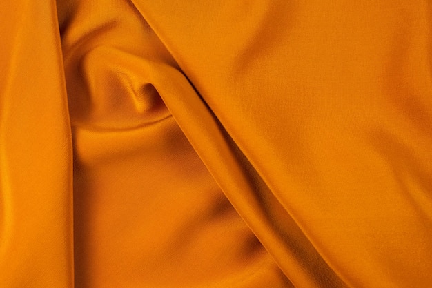 Golden silk or satin luxury fabric texture can use as abstract background