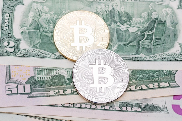 Golden and silver bitcoin on US bank notes