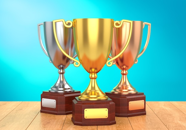 golden silver and bronze trophy cups on table
